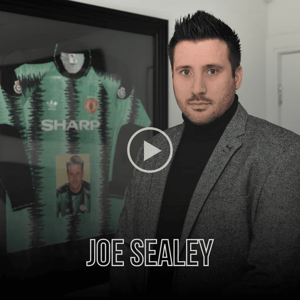 Joe Sealey stands in front of a framed vintage green Manchester United goalkeeper jersey.